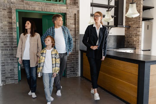 Family exploring a new house guided by a real estate agent, showcasing the modern kitchen.